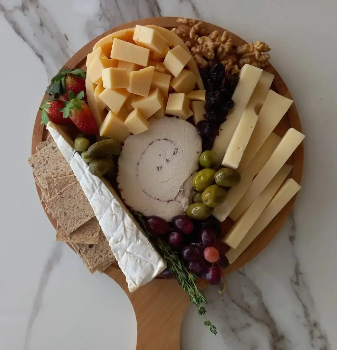 Board with brie, cheese cubes and crackers