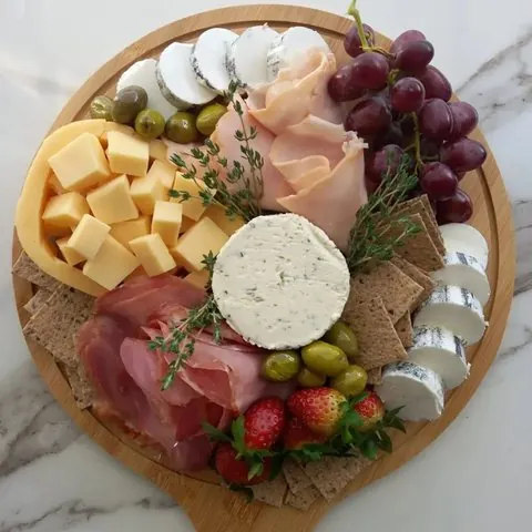 Round board with goat cheese and grapes